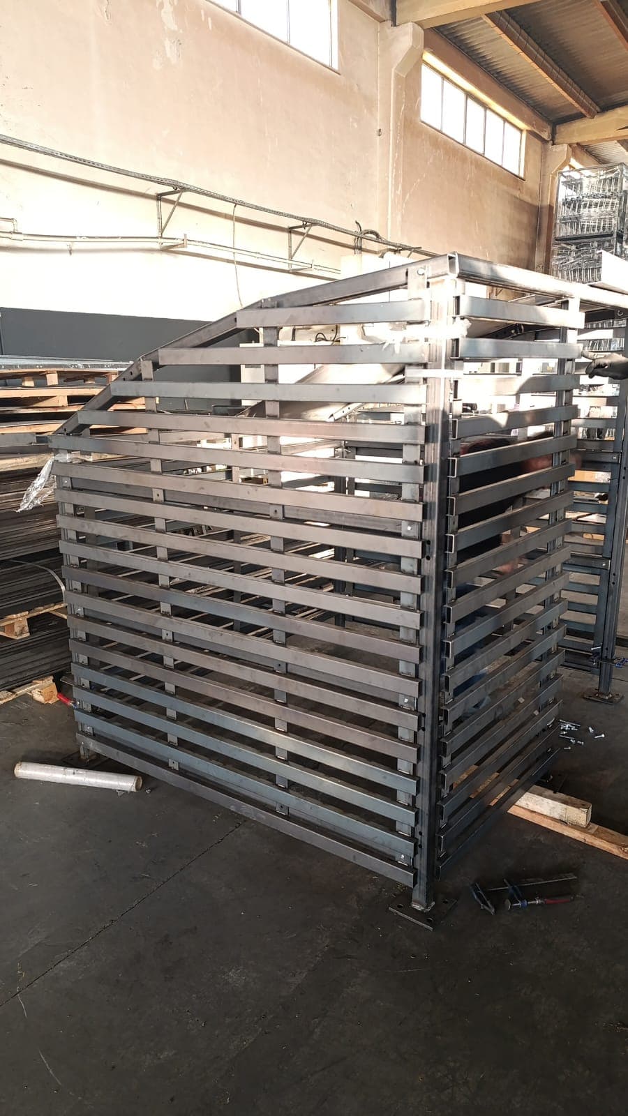 Welded steel crate-style rack frame in a fabrication workshop