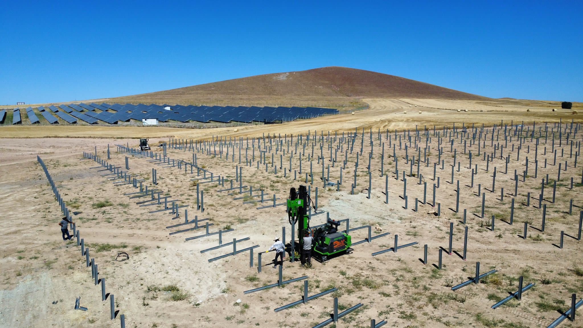 Steel piles installed in rows for a ground-mounted solar panel array at sunset