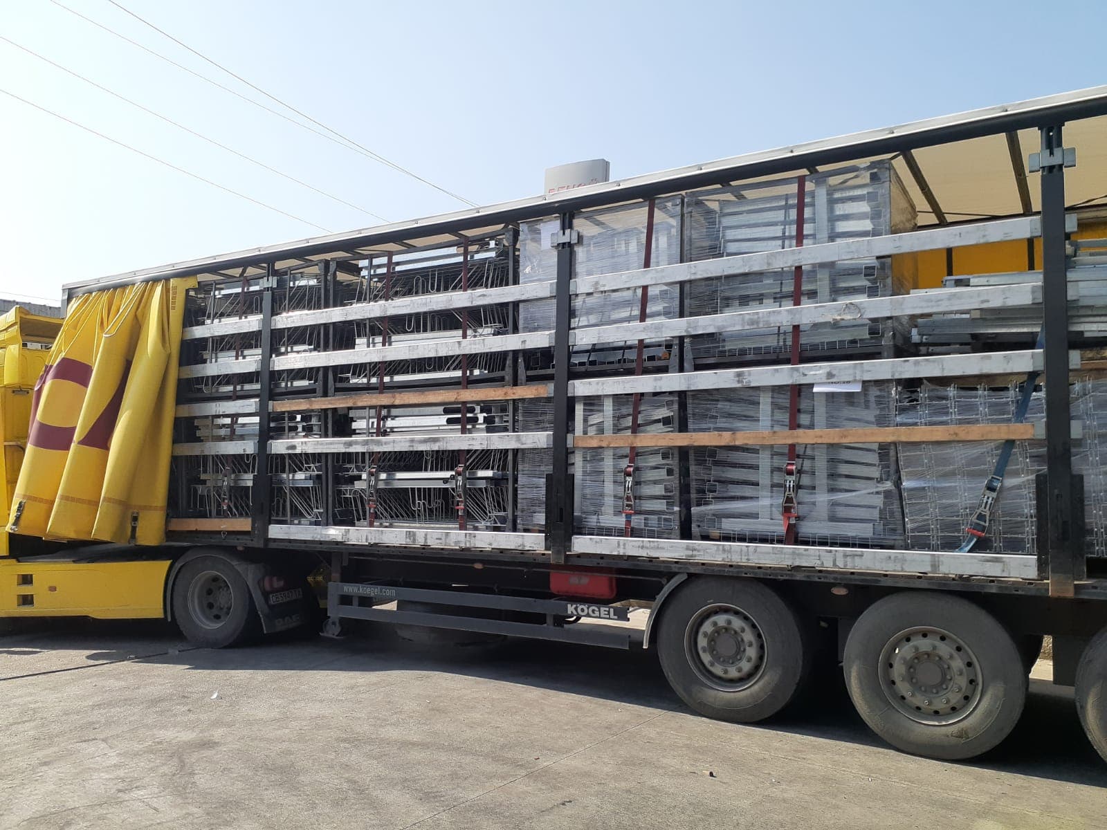 Curtain-side truck loaded with galvanized steel framing components for delivery