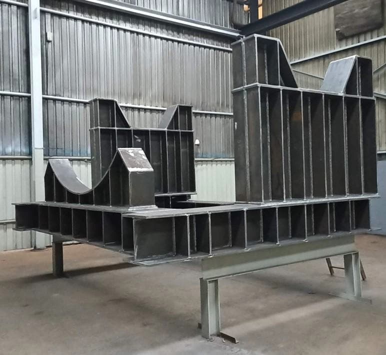 Fabricated structural steel frame with curved sections ready for installation