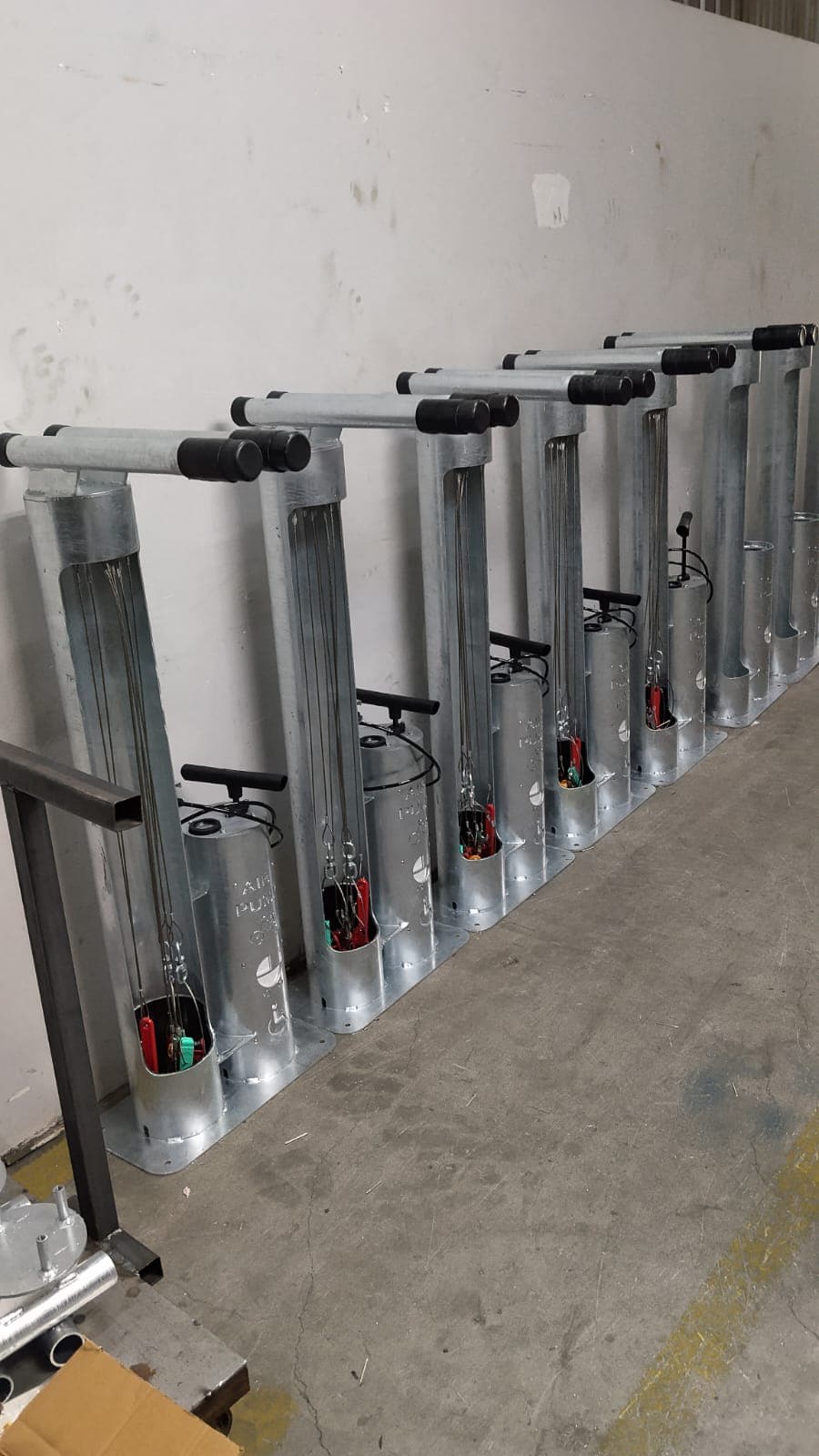 Row of galvanized steel bike repair stands with integrated air pumps in a workshop