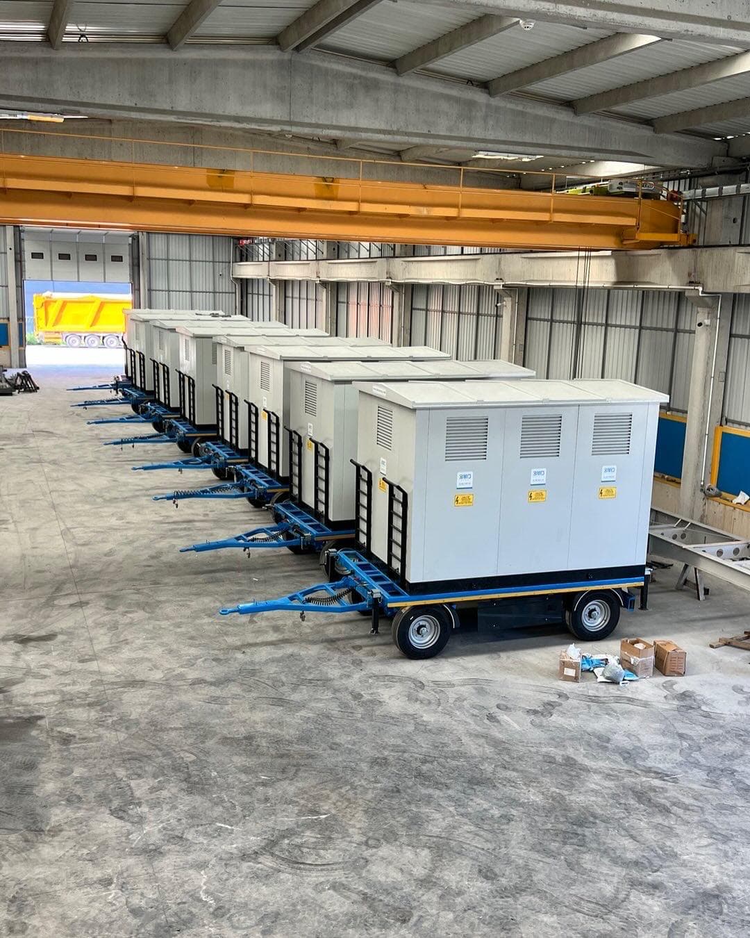 Row of towable mobile substation trailer units inside a factory